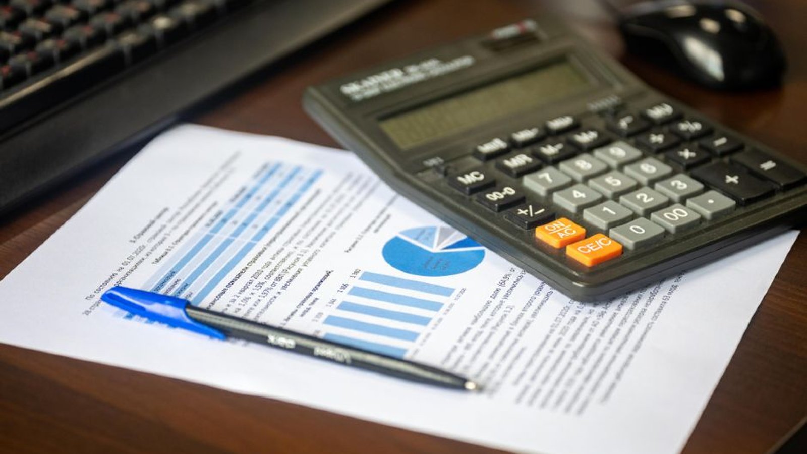 Calculatrice et documents comptables posés sur un bureau de travail